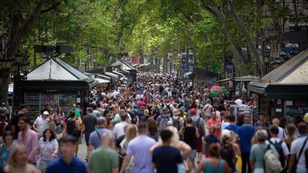 Imagen de una multitud de turistas paseando por la Rambla de Barcelona