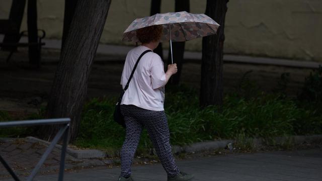 Una mujer paseando bajo un paraguas en Barcelona