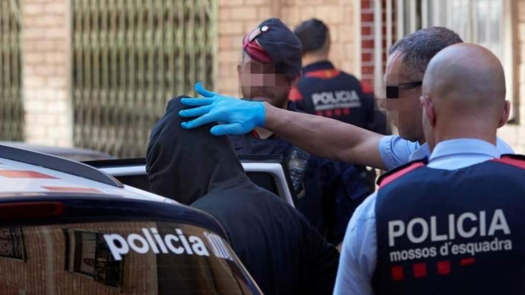 Agentes de los Mossos con un detenido