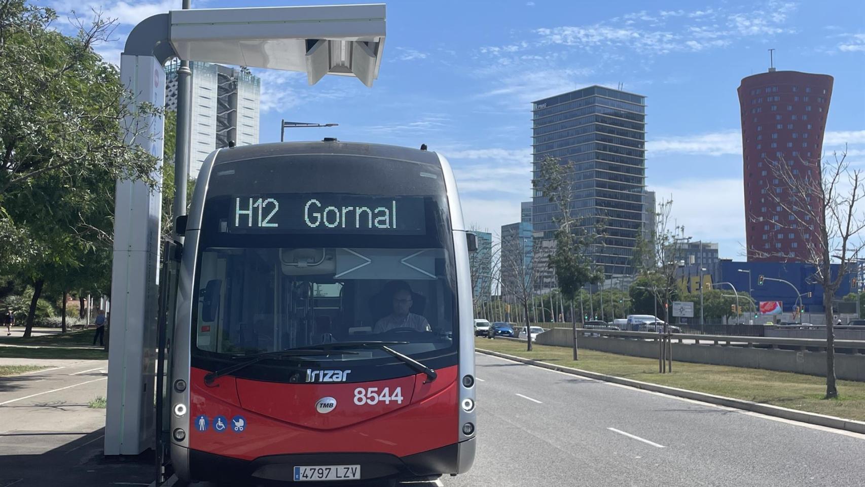 Un autobús eléctrico de la línea H12 de TMB, debajo de uno de los cargadores rápidos ubicados en Gran Via de L'Hospitalet