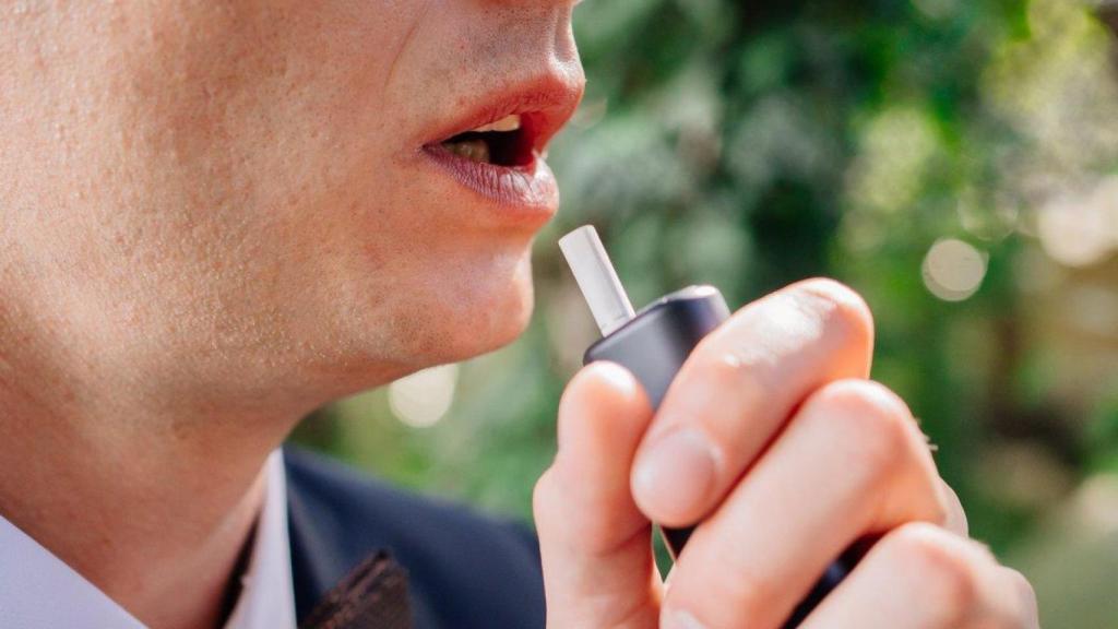 Persona fumando con tabaco calentado