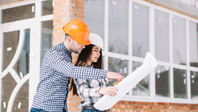 Una pareja revisa los planos de una construcción de obra nueva