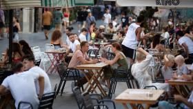 Varias personas sentadas en terrazas en la plaza dels Àngels del Raval en Barcelona