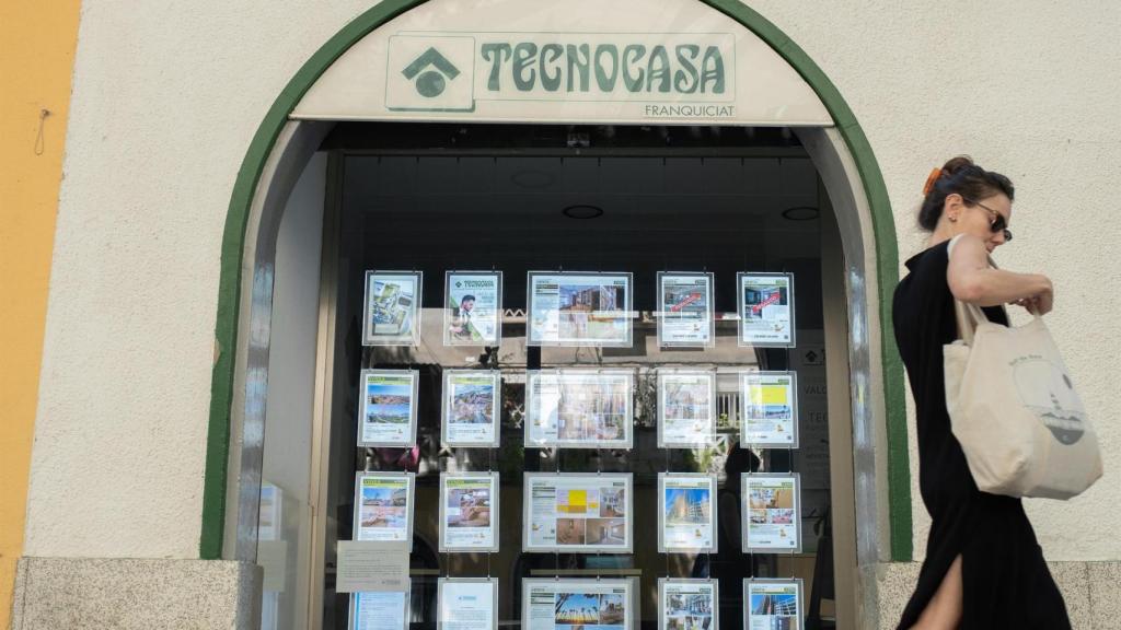 Una mujer pasa por delante de una inmobiliaria en Barcelona