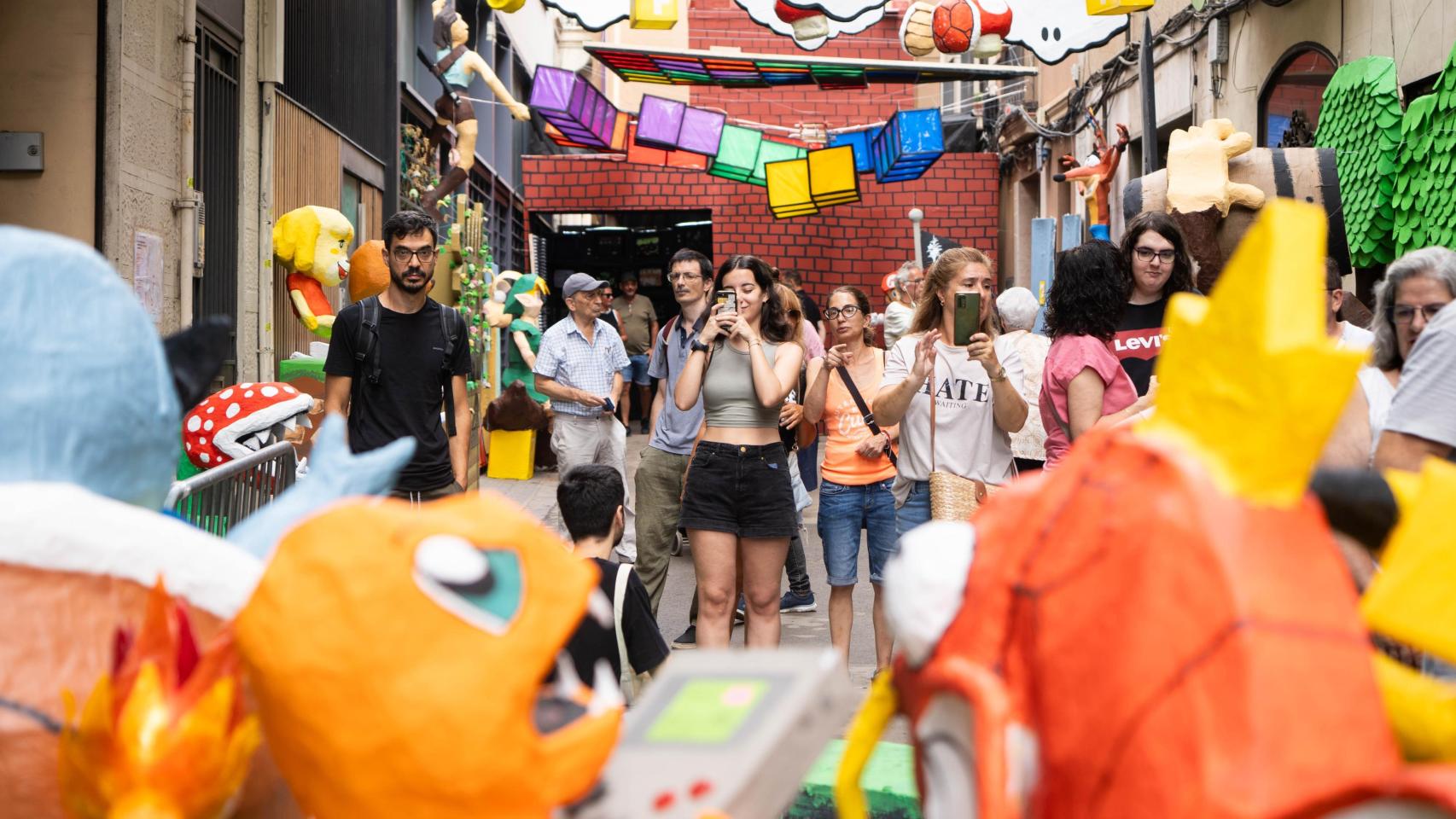 Visitantes fotografían una calle decorada del barrio de Gràcia 2024