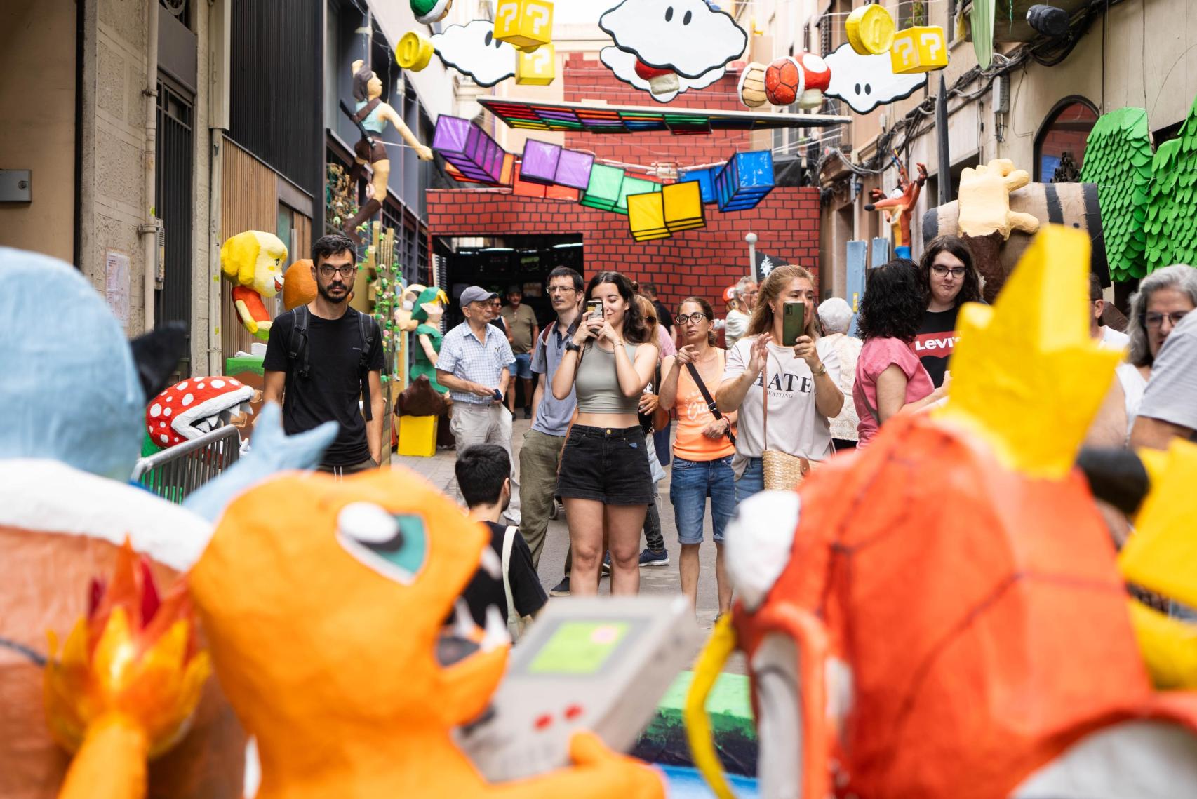 Visitantes fotografían una calle decorada del barrio de Gràcia 2024