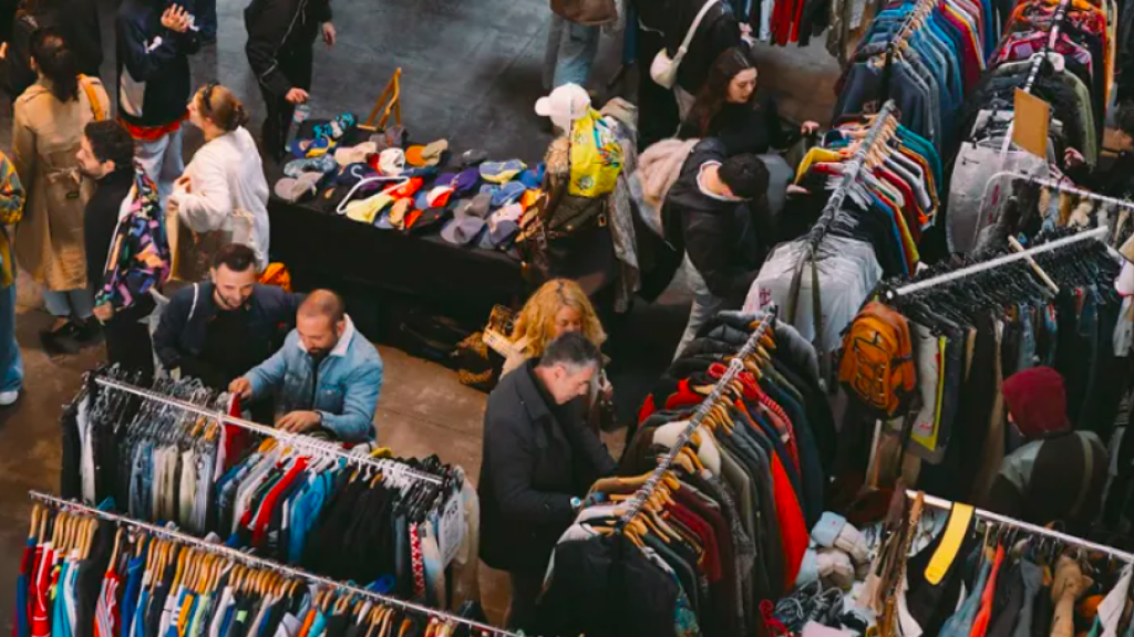 Gente mirando ropa de segunda mano en un mercadillo de Barcelona