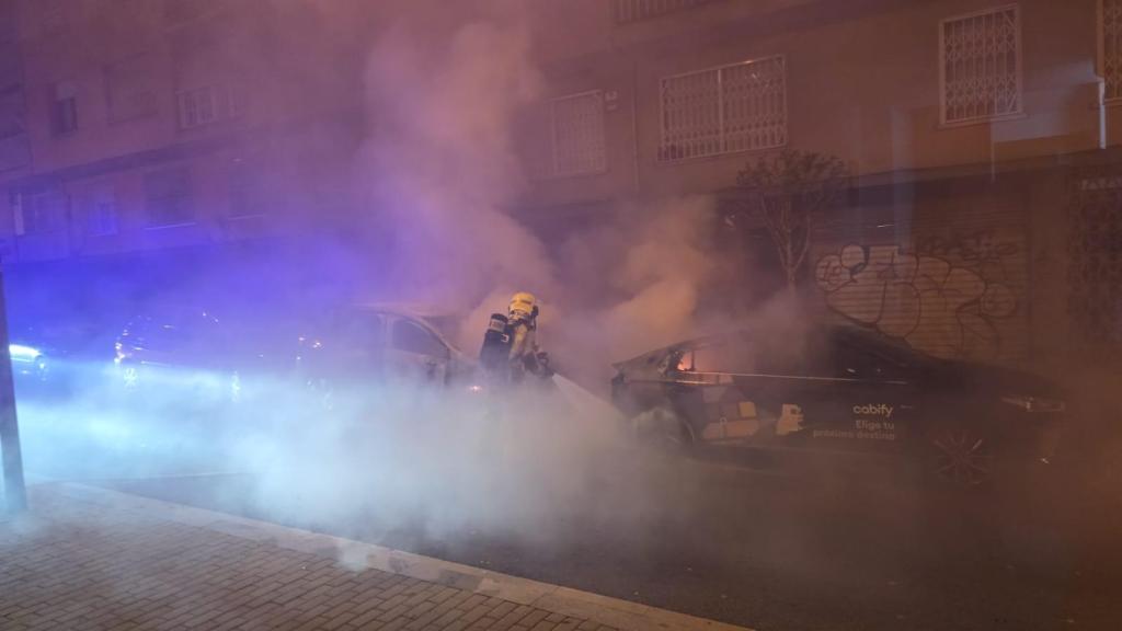 Un bombero apaga un coche incendiado en la calle de les Monges de Sant Adrià de Besòs