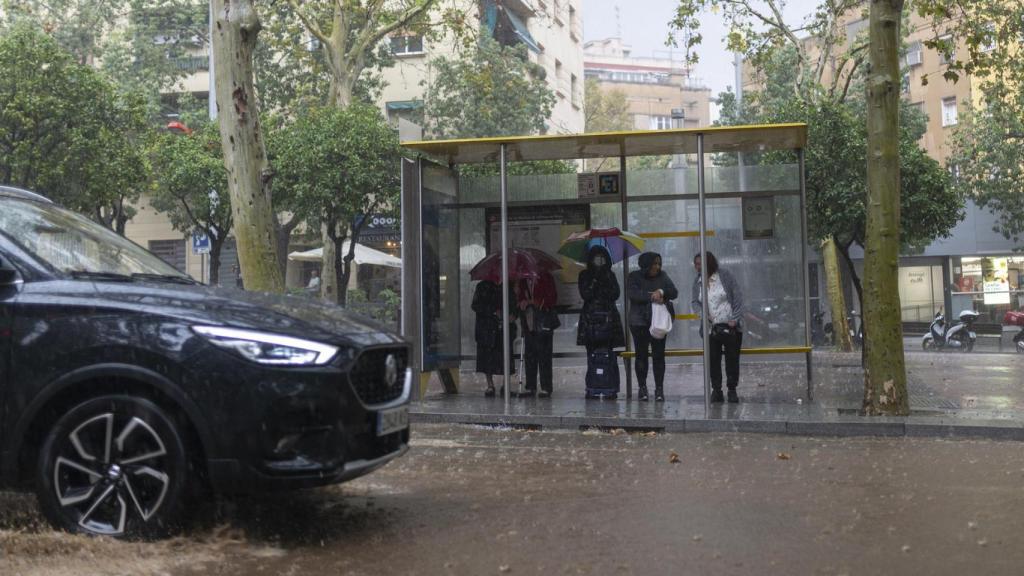 Varias personas esperan en la parada del bus, a 30 de octubre de 2024, en Barcelona