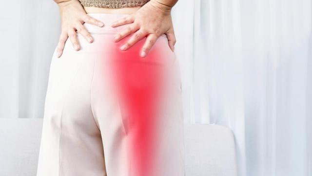 Una mujer se queja de un dolor que le baja del glúteo a la pierna, uno de los síntomas de una hernia discal