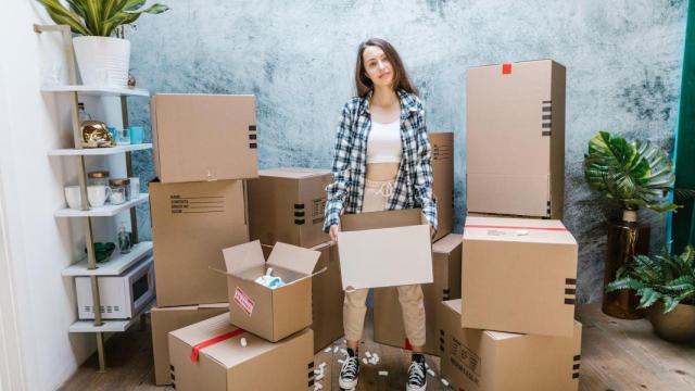 Mujer rodeada de cajas para una mudanza