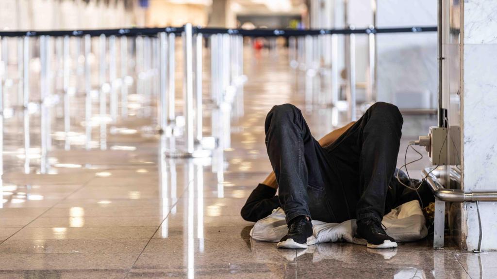 Una persona sin hogar durmiendo en el Aeropuerto de Barcelona