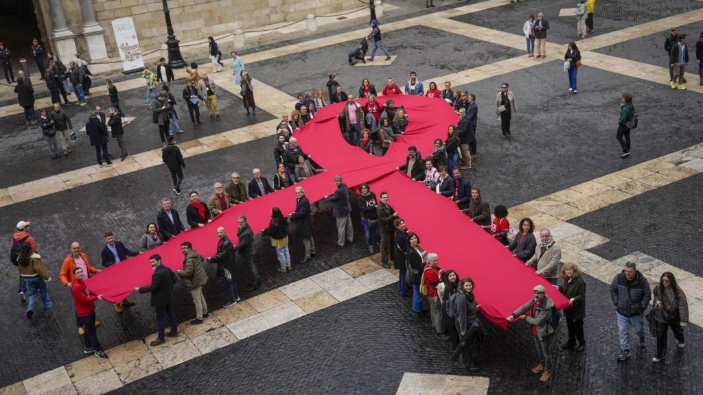 Un lazo memorial del Sida de despliega en la plaza Sant Jaume este domingo, en el que se celebra el Día Mundial del Sida