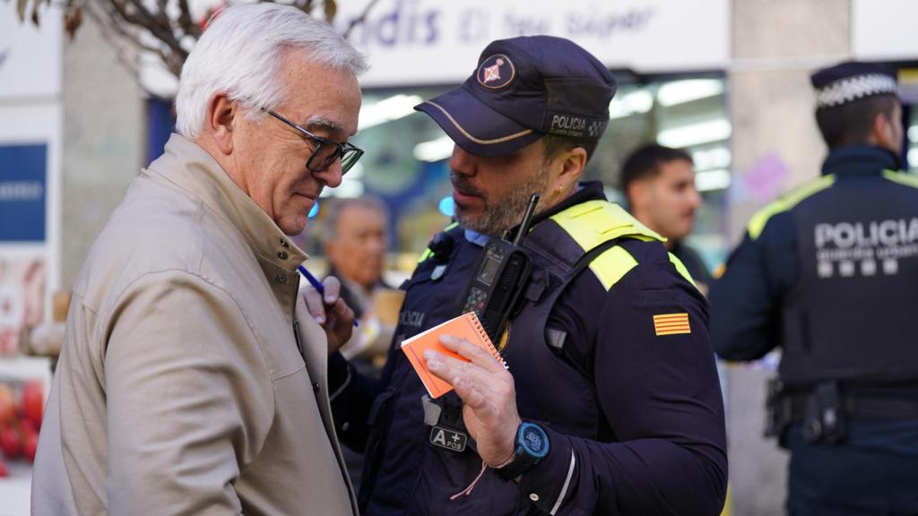 Un agente de la Guardia Urbana de Barcelona con un señor mayor