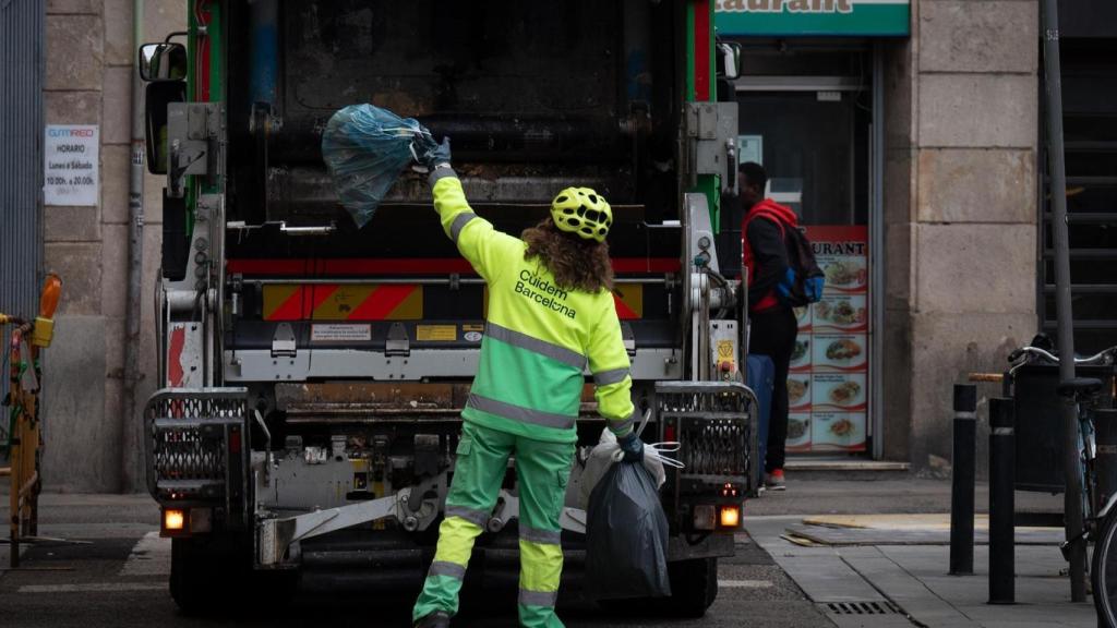 Una persona del servicio municipal de limpieza recoge basura en Barcelona