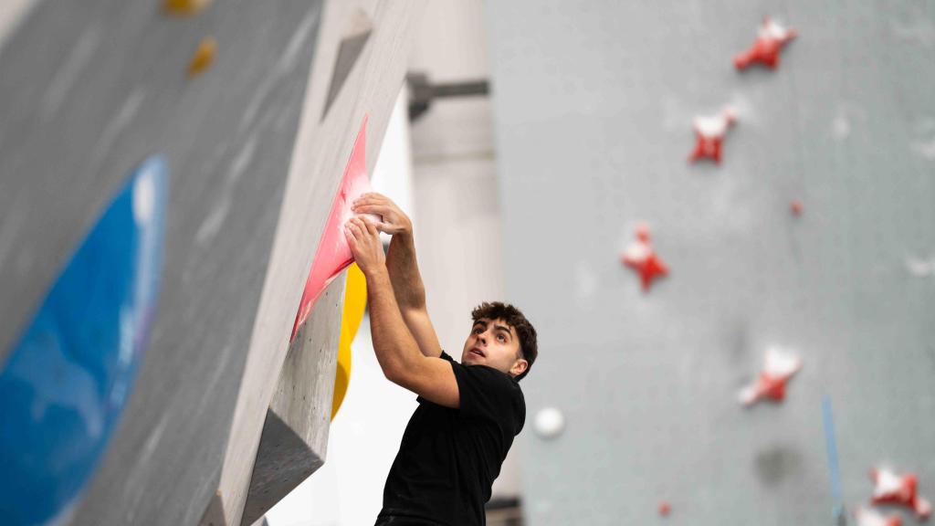 Joven escalando una pared de búlders en el Sharma Climbing de Gavà