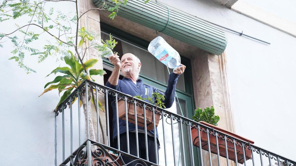 Vecino del Raval ve la manifestación contra el desalojo de la Antiga Massana desde el balcón