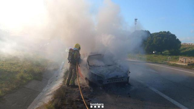 Coche quemado en una carretera de El Prat de Llobregat