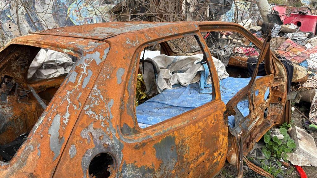 Uno de los coches calcinados en el solar abandonado de la Vía Trajana