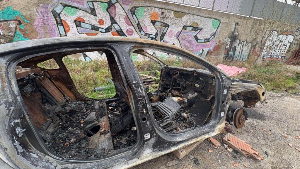 Uno de los coches calcinados en el solar abandonado de la Vía Trajana