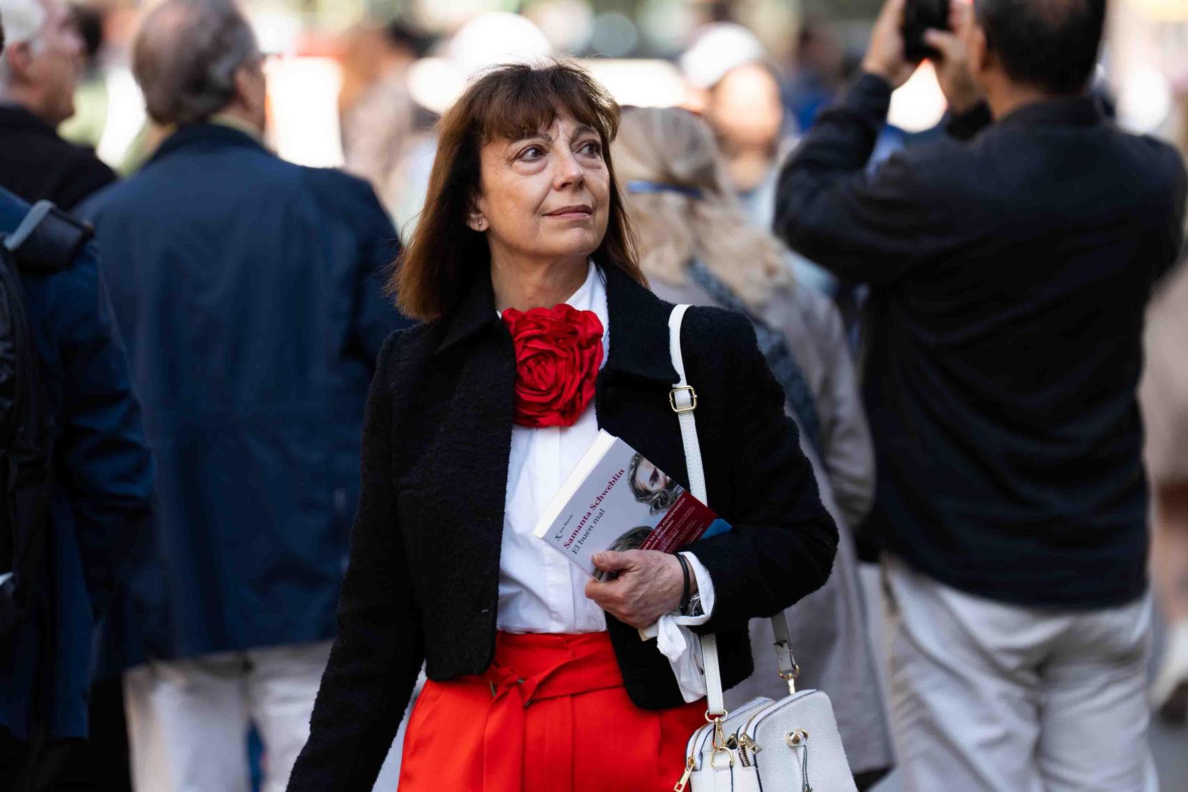 Una mujer pasea con un libro en la mano por el día de Sant Jordi