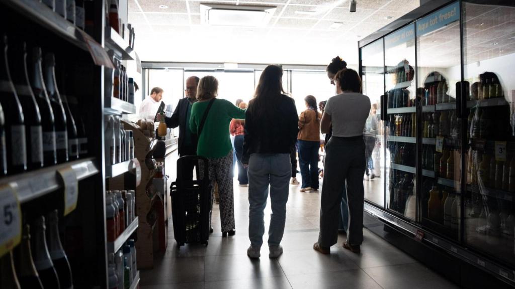 Un grupo de trabajadores y clientes en un supermercado a oscuras durante la jornada del apagón en Barcelona