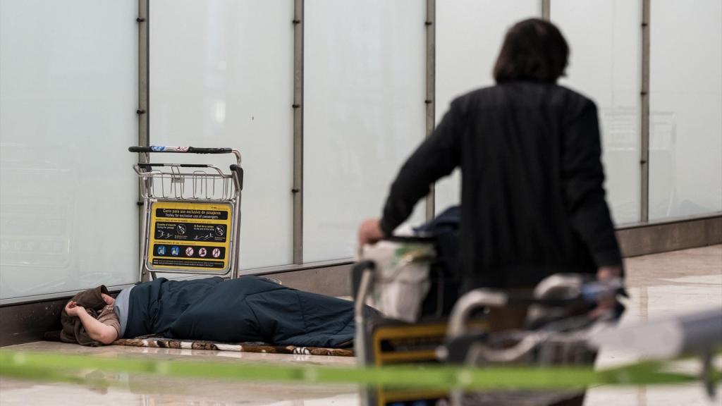 Una persona sin hogar durmiendo en el Aeropuerto de Barajas