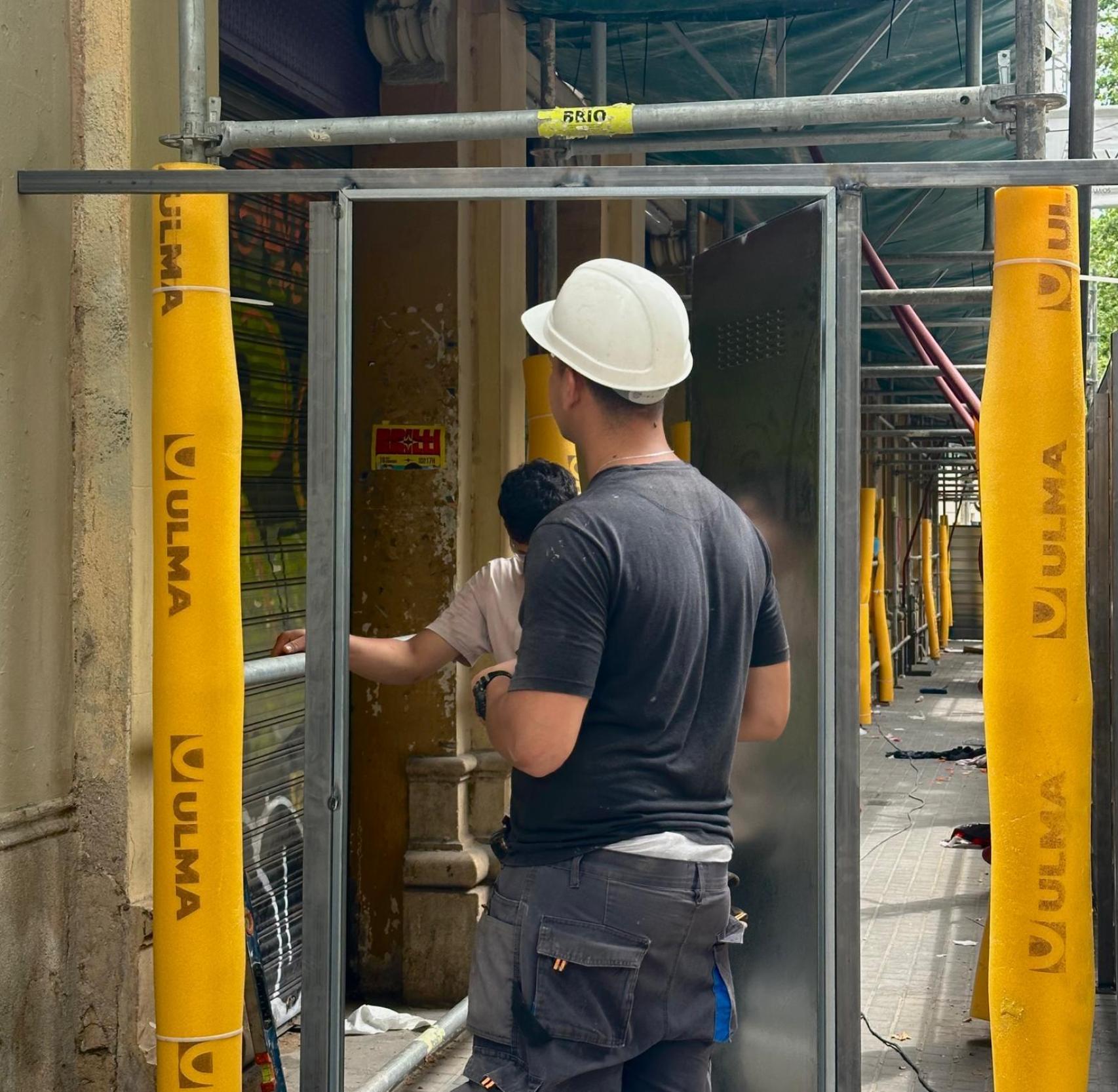 Imagen de los trabajadores montando la puerta metálica