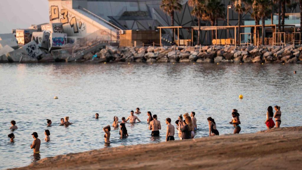 Expats en la playa de la Barceloneta durante el amanecer