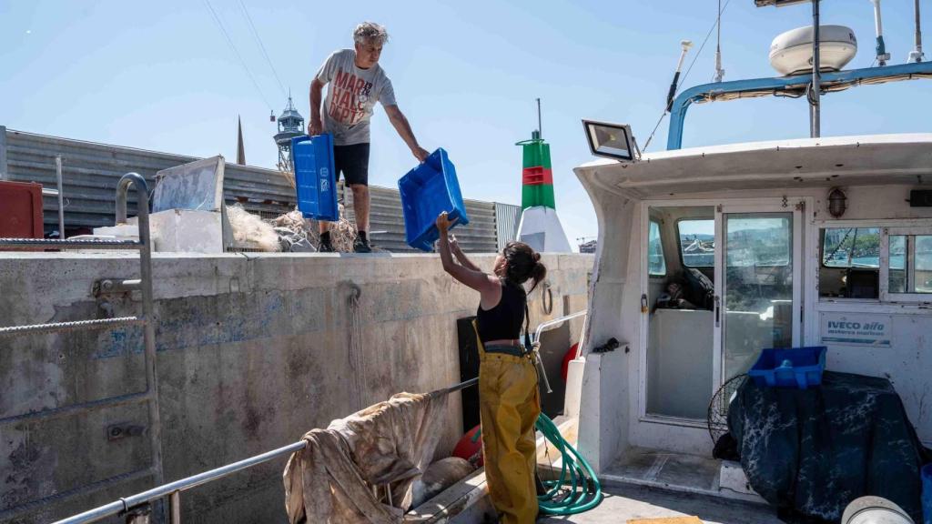 Rafa, el padre de Alba dándole las cubetas para que pueda preparar el pescado del día