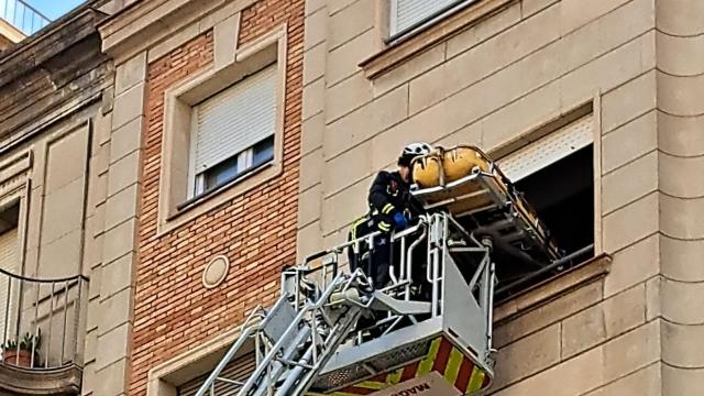 Los bomberos extraen a una persona por la ventana de su domicilio en Gràcia