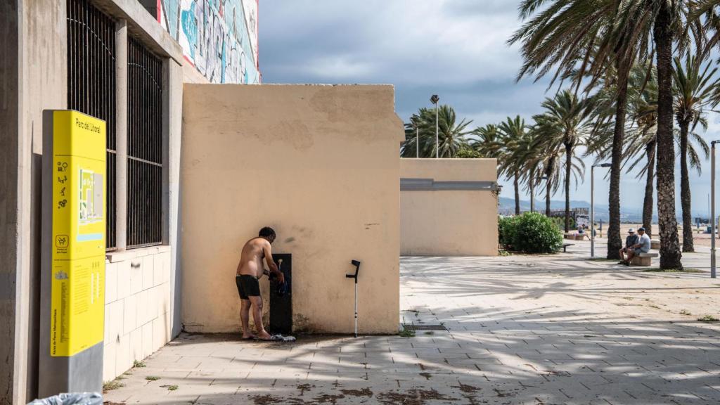 Un hombre lavando su ropa en la playa del Litoral de Sant Adrià