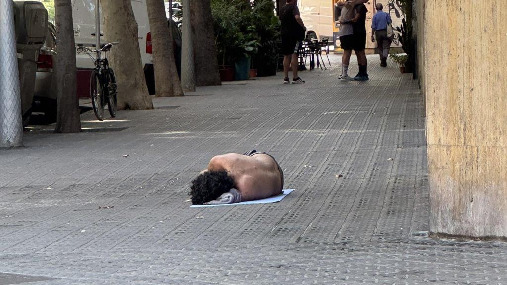 Una persona sintecho en el suelo, en el barrio de Sant Antoni