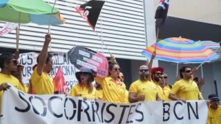 Varios socorristas protestan durante la huelga indefinida en Barcelona, frente a la sede del PSC