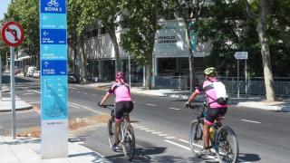 Dos ciclistas pedalean por un carril bici de Bicivia en el área metropolitana